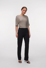 Modell med guldbeige Ursula-topp och svarta Zamira slim straight-byxor